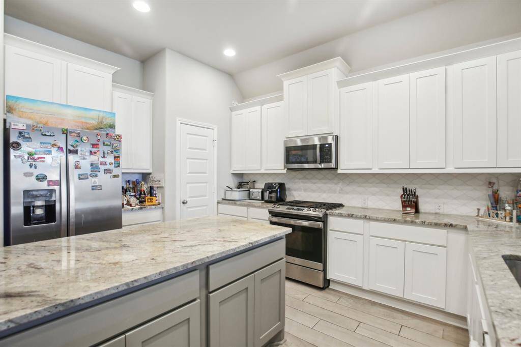 The kitchen boasts generous counter space complemented by sleek granite countertops and a large central island, perfect for both meal prep and entertaining.