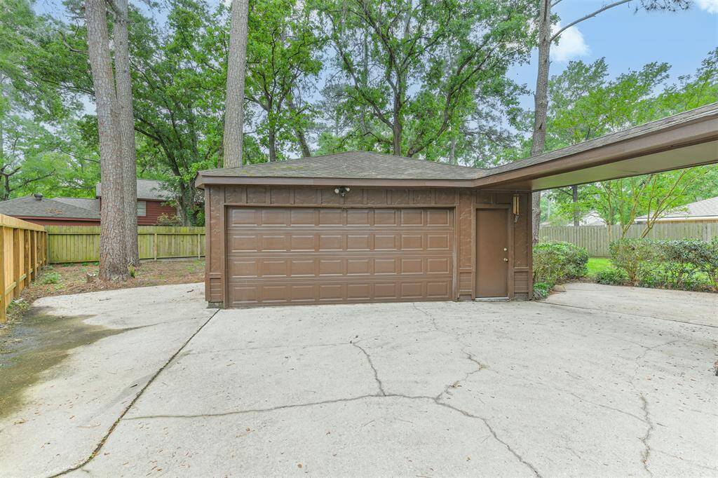 Detached garage with extra parking space on driveway behind a gate, great for small boat or camper