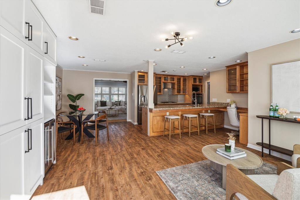 View of the open living space and kitchen from the back door to the patio.  You can see the there is also a nice built in desk nook with shelving to the right.