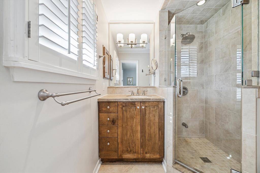 The primary full bathroom is thoughtfully designed and features wood shutters matching to the bedroom.