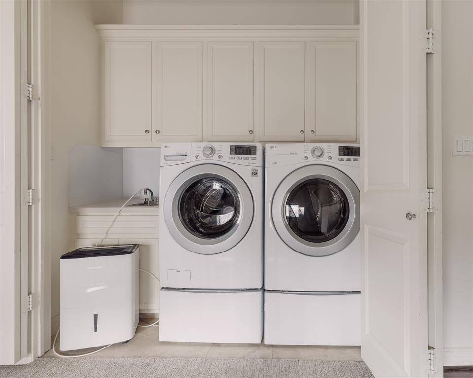 Laundry room with a sink and cabinets