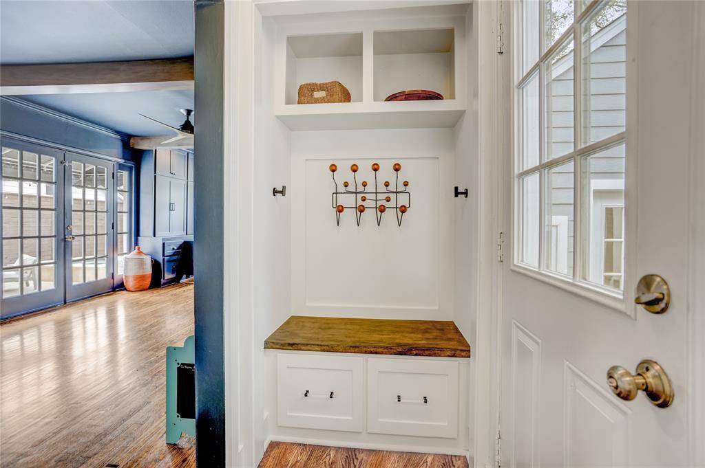 Convenient backdoor access from the covered carport leads to an elegant mudroom, centrally connecting the kitchen, family room, and living areas.