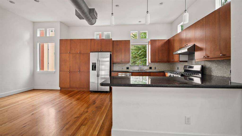 Modern kitchen with plenty of cabinet space, sleek countertops, and stainless steel appliances for a functional and stylish cooking experience.