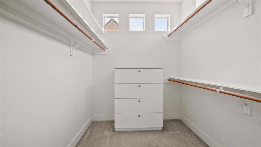 Spacious walk-in closet with built-in small drawers, offering plenty of storage and organization.