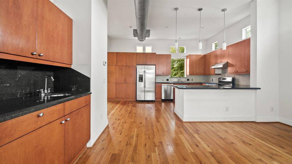 The wet bar flows into the open kitchen, offering sleek countertops and ample storage, ideal for entertaining.