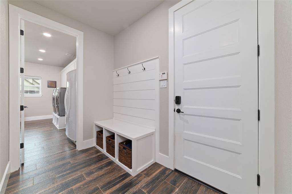 Conveniently located just before the laundry room is a spacious mudroom, providing a perfect drop zone for bags, shoes, and daily essentials. It’s connected to the oversized two-car garage with 8’ high doors, ideal for accommodating taller vehicles with ease.