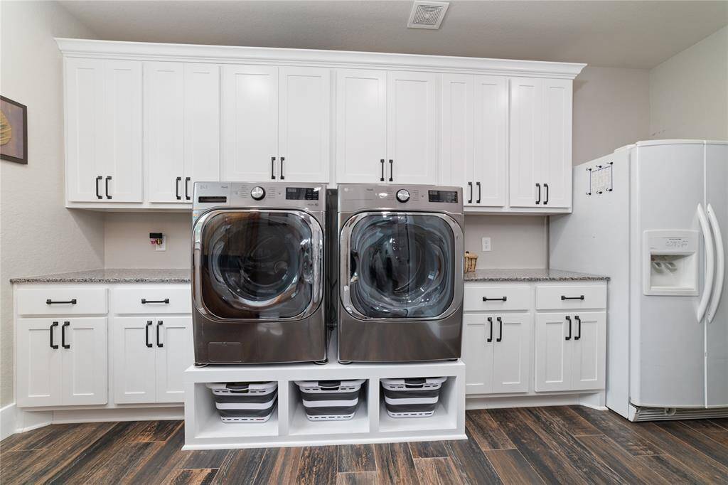Enormous laundry room featuring custom built-in drawers designed specifically to hold laundry baskets, keeping everything neatly tucked away and making laundry day more efficient and organized!