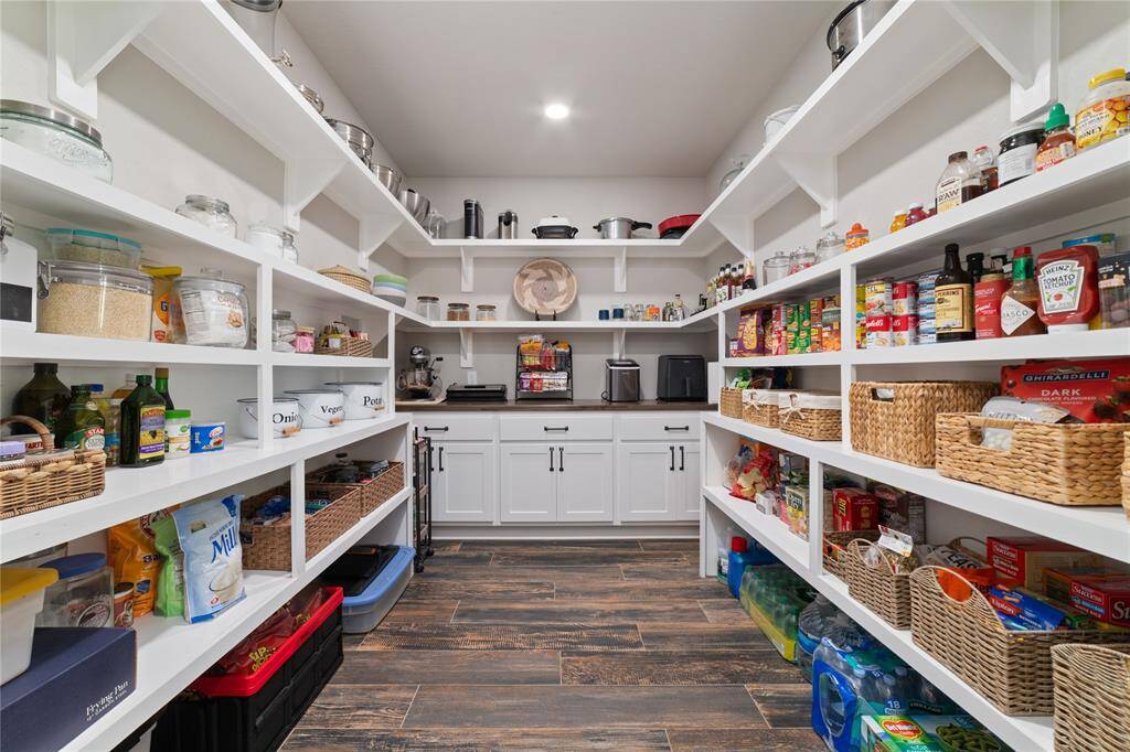 Enormous walk-in pantry offers a dream storage solution for all your favorite appliances, dry goods, and gourmet chef essentials—perfect for keeping your kitchen organized and clutter-free!