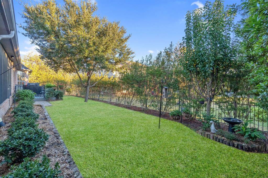 The homeowner has a green thumb and you will be pleasantly surprised with the beautiful spring flowers and bright colors you will have in your backyard.  Behind the luscious wall of trees there is a beautiful wrought iron fence to keep your fur babies in.