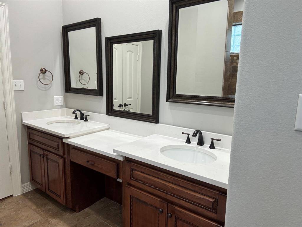 Elegant primary bath with a spacious double-sink vanity, newly installed quartz countertops and new sinks.