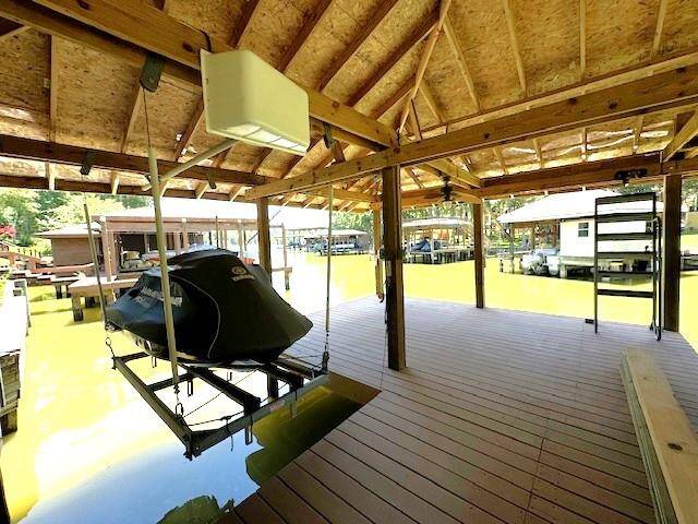 Enjoy seamless lake access with a boathouse featuring a jet ski lift, spacious deck, and convenient metal stairs.