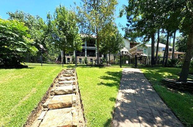 Discover easy backyard and boathouse access with stone steps on the left or a convenient cart path featuring a solar-powered, remote-controlled gate on the right.