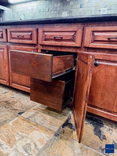 This kitchen features rustic wooden cabinetry with a warm finish and practical pull-out drawers for easy storage.