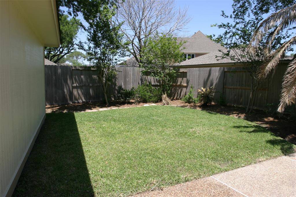 Backyard w/grass behind garage.