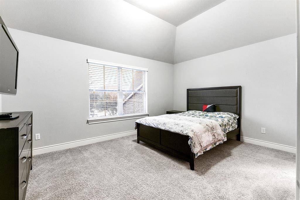 This home offers a total of five bedrooms. Upstairs, you'll find a spacious bedroom complete with a walk-in closet, plush carpeting, a ceiling fan, and window treatments. This room is connected to a Hollywood-style bathroom, which features a walk-in closet and ceiling fan, offering both convenience and comfort.