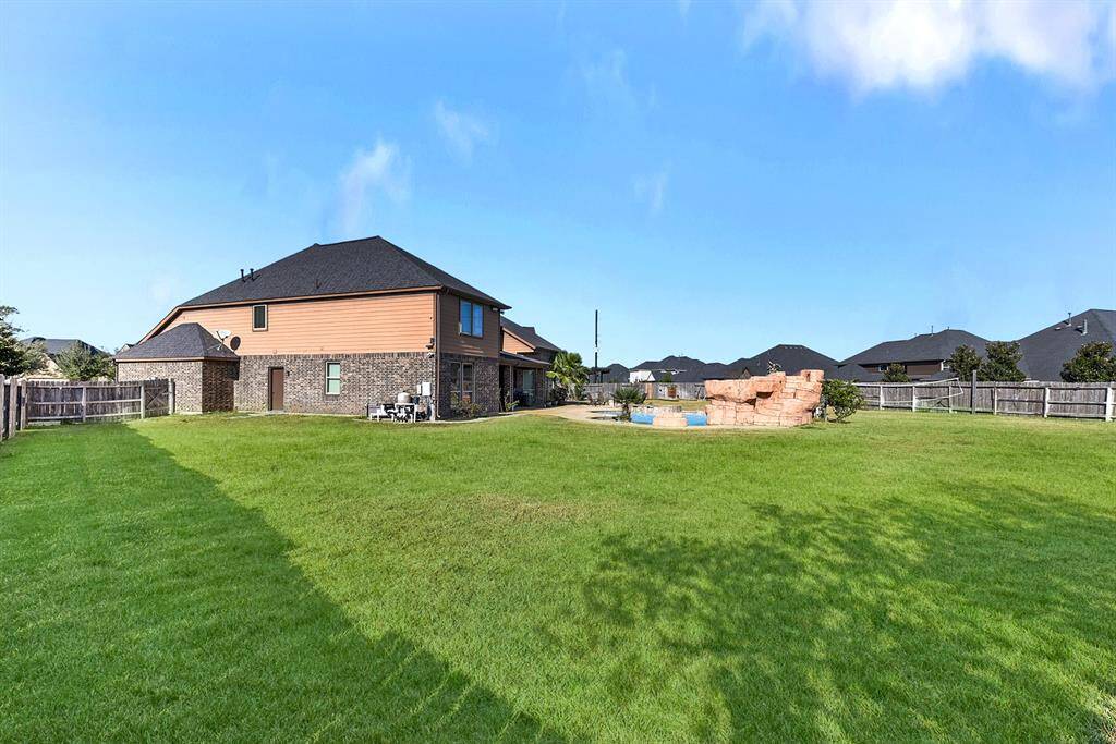This spacious backyard offers plenty of room for entertaining, featuring an oversized covered patio with cool-deck concrete, ceiling fan, and lighting. The home’s exterior is beautifully finished with brick on all four sides. The backyard is complete with a large covered patio, fire pit, and a heated swimming pool and spa, creating the perfect setting for relaxation and outdoor gatherings.