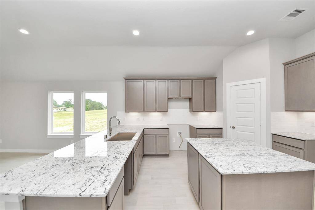 This kitchen is by far any chef’s dream! This spacious kitchen features high ceilings, light stained wood cabinets, granite countertop, SS appliances, modern tile backsplash, recessed lighting, extended counter space, granite kitchen island, and space for breakfast bar, and a walk-in pantry all overlooking your huge family room.