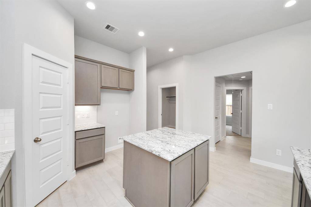 Discover another perspective of this stunning kitchen, generously appointed with an abundance of counter space