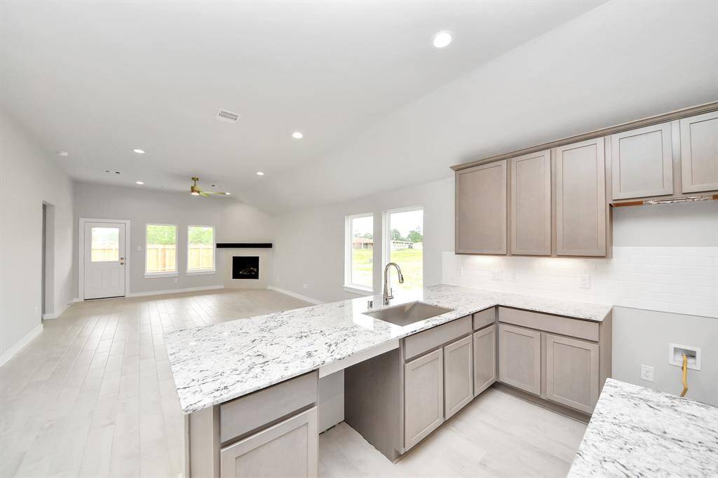Culinary haven, featuring granite countertops, a tile backsplash, stainless steel appliances (to be installed), and 42” upper cabinets.