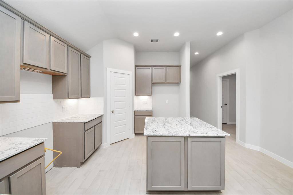 Discover another perspective of this stunning kitchen, generously appointed with an abundance of counter space