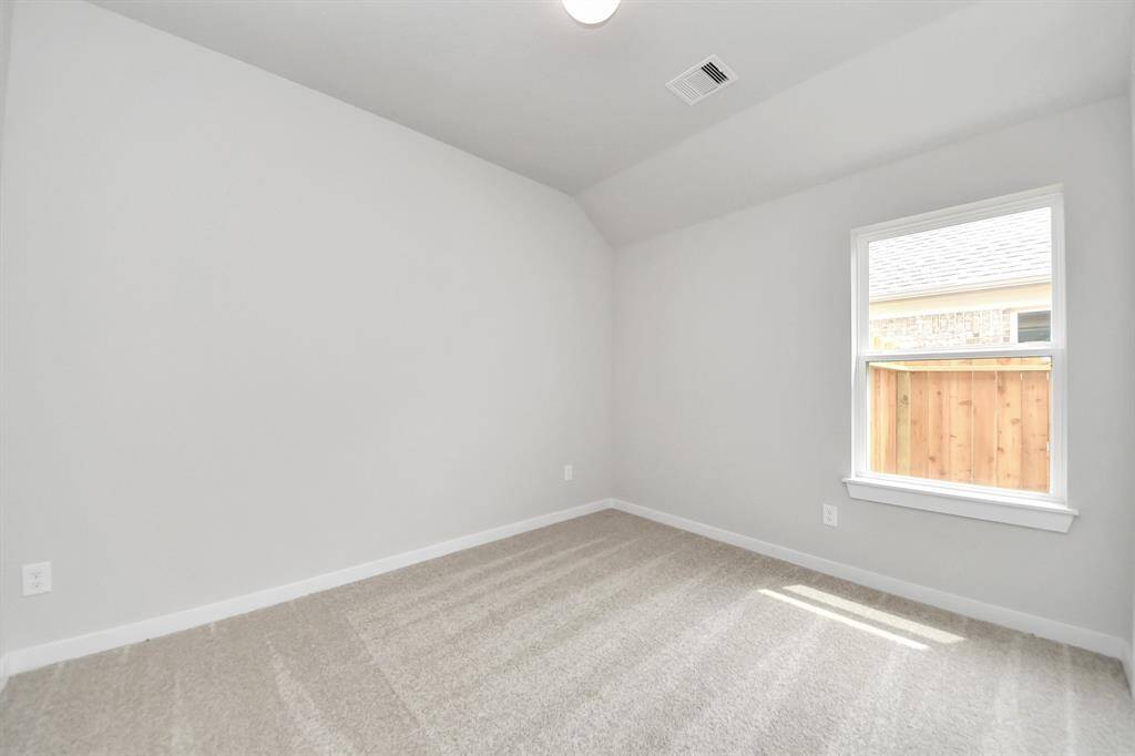 Secondary bedroom features plush carpeting, large windows that let in plenty of natural light, bright paint, and spacious closets.