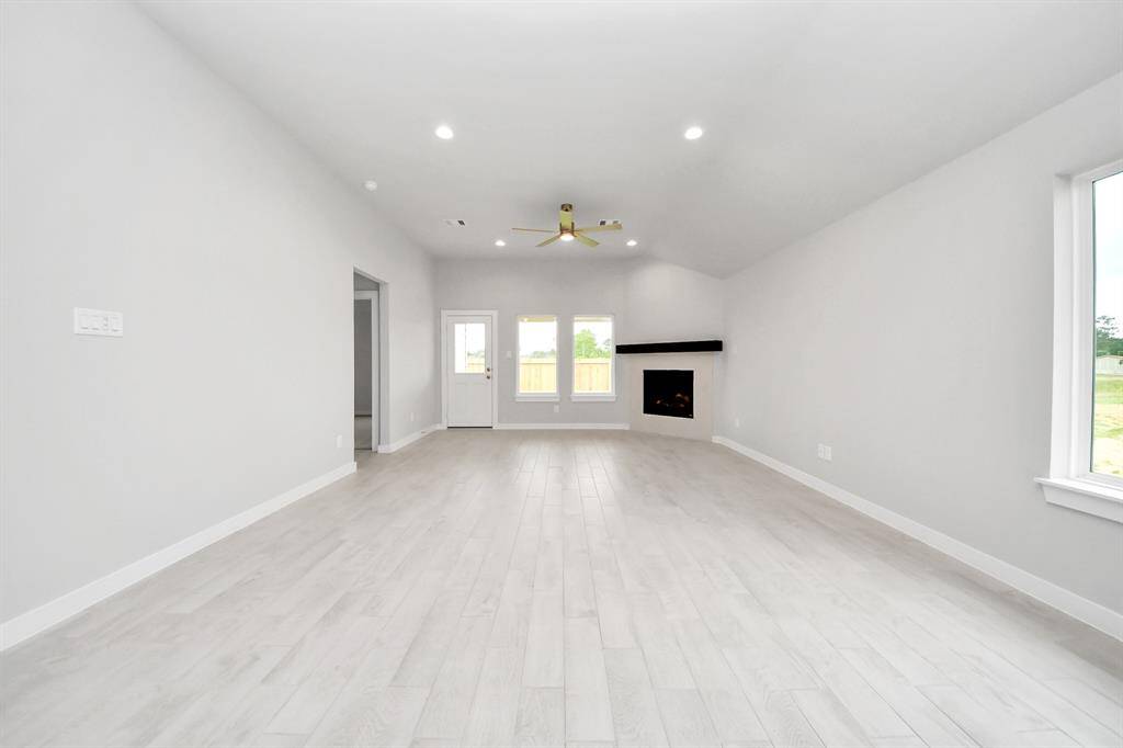 Family room flooded with natural light through the expansive windows.  The premium tile flooring adds a touch of luxury to the space, creating the perfect setting for relaxing moments and cherished gatherings with loved ones