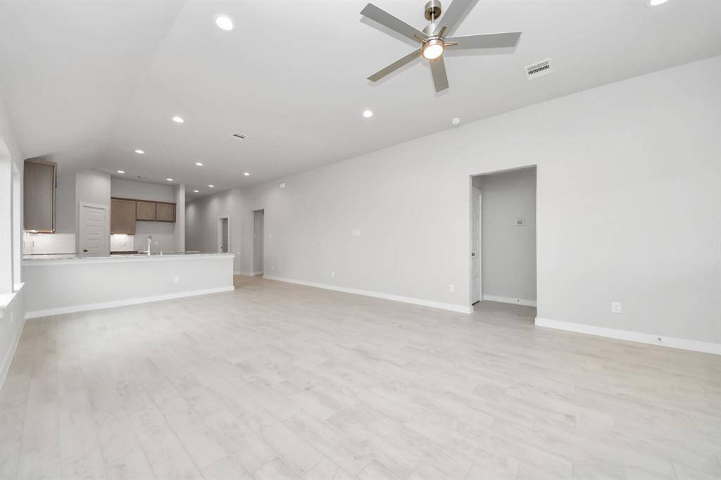 Gather the family and guests together in your lovely living room! Featuring soaring high ceilings, recessed lighting, ceiling fan, custom paint, gorgeous floors, and large windows that provide plenty of natural lighting throughout the day.