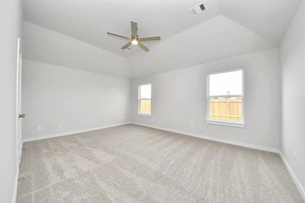 Escape and relax in the exquisite primary suite, a haven to unwind after a long day. The spacious room, boasts plush carpeting, soothing paint tones, high ceilings, and expansive windows adorned with privacy blinds.
