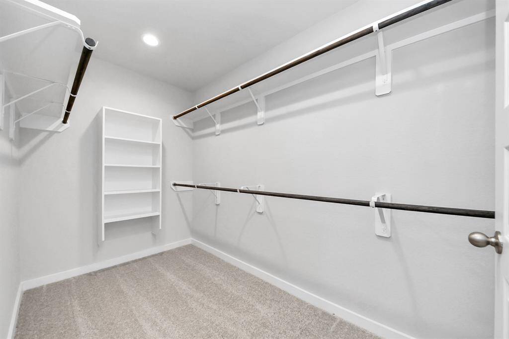 Walk-in closet that epitomizes luxury and practicality. This generously sized space features built-in shelving, offering abundant room for impeccable organization. High ceilings and recessed lighting create a bright and welcoming ambiance.