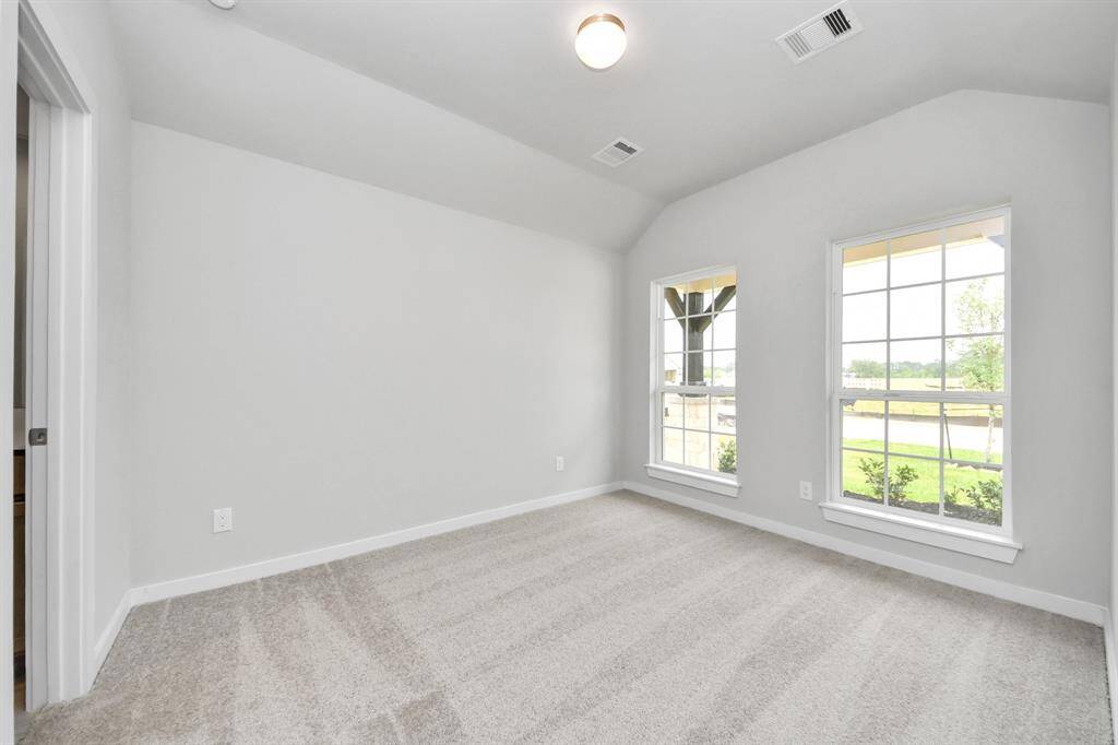 Secondary bedroom features plush carpeting, large windows that let in plenty of natural light, bright paint, and spacious closets.