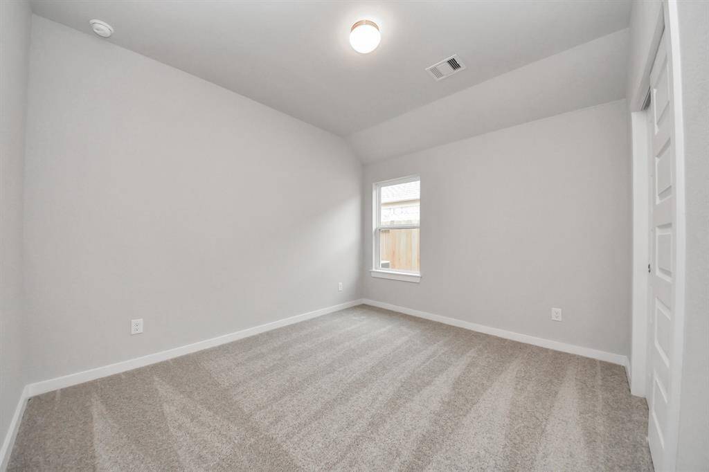 Secondary bedroom features plush carpeting, large windows that let in plenty of natural light, bright paint, and spacious closets.