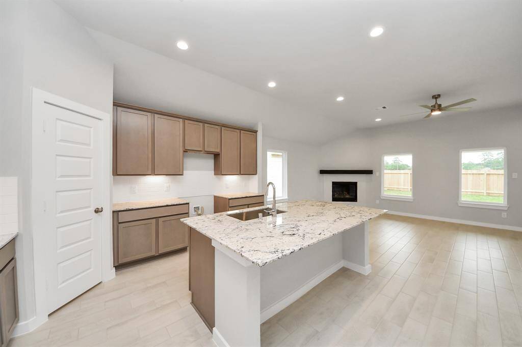 This kitchen is by far any chef’s dream! This spacious kitchen features high ceilings, stained wood cabinets, granite countertop, SS appliances, modern tile backsplash, recessed lighting, extended counter space, granite kitchen island with double sink, and space for breakfast bar, and a walk-in pantry all overlooking your huge family room.