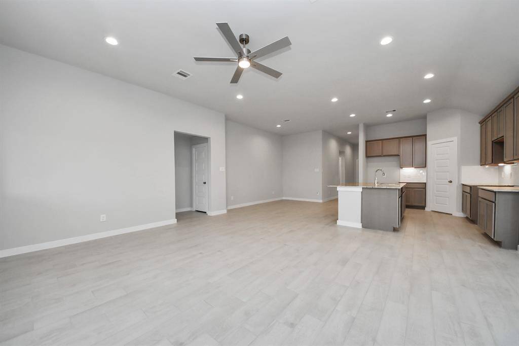 Gather the family and guests together in your lovely living room! Featuring soaring high ceilings, recessed lighting, ceiling fan, custom paint, gorgeous floors, and large windows that provide plenty of natural lighting throughout the day.