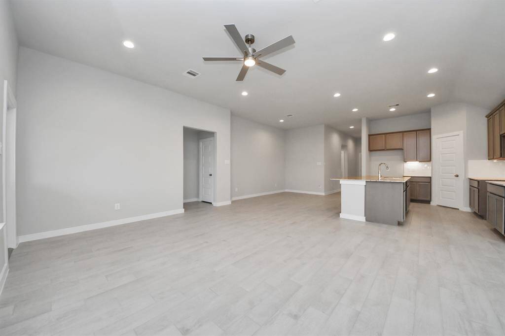 Family room flooded with natural light through the expansive windows.  The premium tile flooring adds a touch of luxury to the space, creating the perfect setting for relaxing moments and cherished gatherings with loved ones