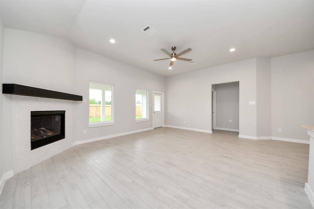 Family room flooded with natural light through the expansive windows.  The premium tile flooring adds a touch of luxury to the space, creating the perfect setting for relaxing moments and cherished gatherings with loved ones