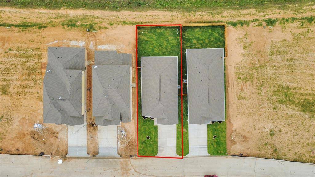 An aerial view of a spacious subdivision lot, highlighting a well-maintained yard and a fully fenced perimeter, offering both privacy and expansive outdoor space.