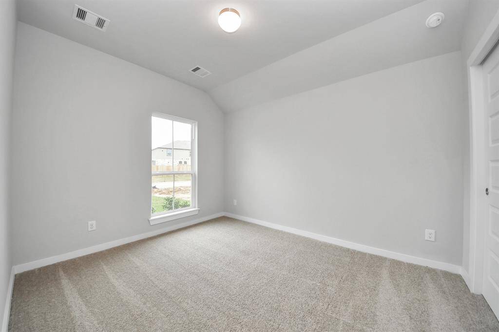 Secondary bedroom features plush carpeting, large windows that let in plenty of natural light, bright paint, and spacious closets.