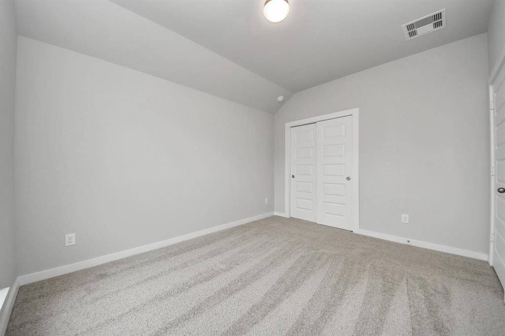 Secondary bedroom features plush carpeting, large windows that let in plenty of natural light, bright paint, and spacious closets.