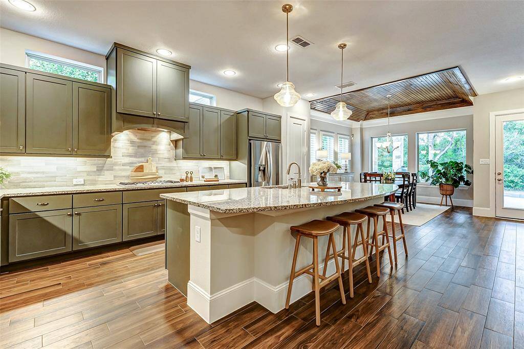 Just beyond the entryway, the heart of the home awaits—this breathtaking kitchen boasts a spacious, open layout perfect for entertaining. The expansive island offers ample workspace and seating, while custom cabinetry with a matching vent hood adds a seamless, designer touch. Undercabinet lighting enhances both functionality and ambiance, completing this beautifully curated space.