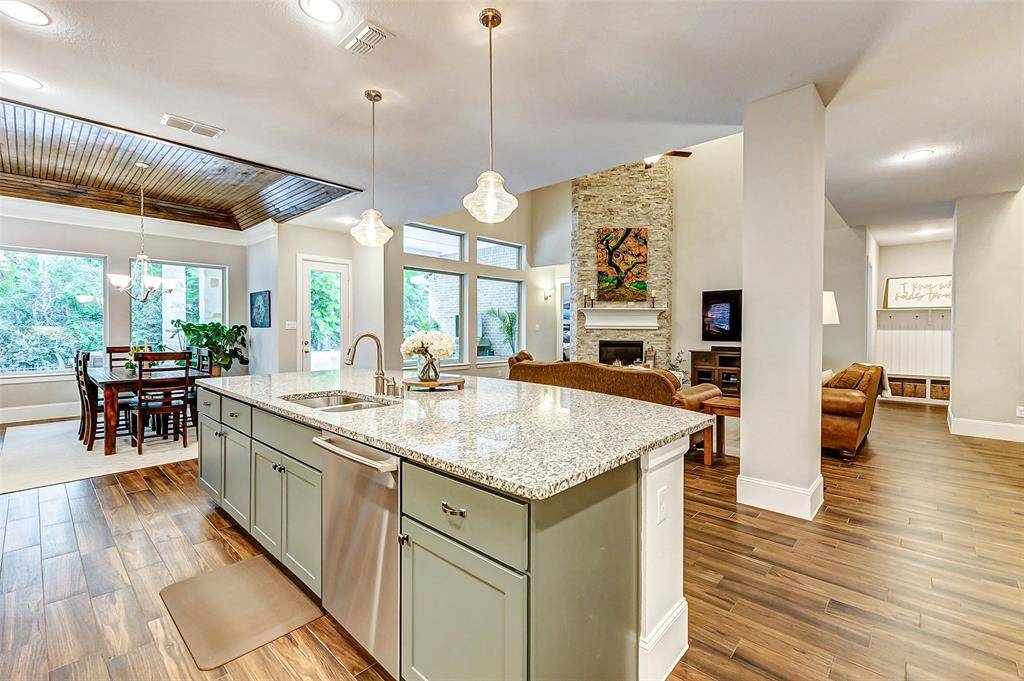 A double-basin under-mount sink is seamlessly integrated into the island, with the dishwasher conveniently located to the right. The island is strategically positioned to offer views of the living room and dining area, creating an open and connected space perfect for both cooking and entertaining.