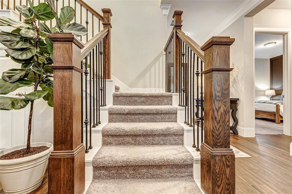 Ascend the stairs, featuring elegant wood railings and iron balusters, to the second level of the home where you will find a game room and your secondary rooms.