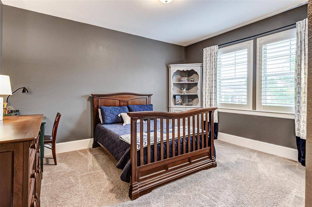 The second upstairs bedroom continues the home’s thoughtful design with decorator paint, thick baseboards, and plush carpeting. A roomy closet and windows with plantation shutters complete this comfortable and stylish space.