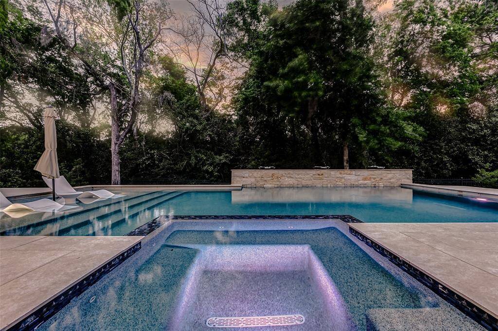 This expansive backyard showcases a stunning swimming pool with an integrated spa—perfect for both relaxation and entertaining. Whether you're hosting guests or enjoying a quiet evening, this outdoor retreat offers the ultimate in luxury and comfort.