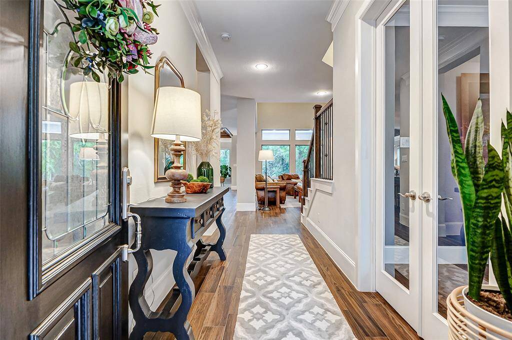 Welcome in! This elegant entryway sets the tone for the entire home, showcasing soaring ceilings and rich wood-look tile flooring that adds warmth and sophistication from the moment you step inside.