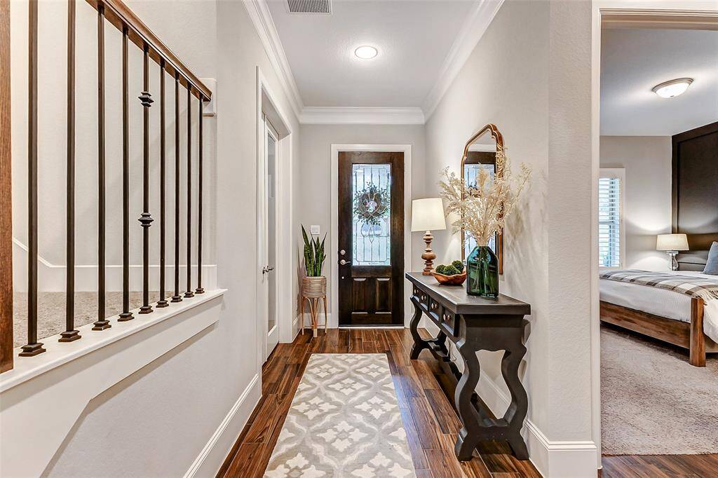 An alternate view of the entryway highlights the thoughtfully placed downstairs guest bedroom and the private study—perfect for hosting visitors or working from home in comfort and quiet.