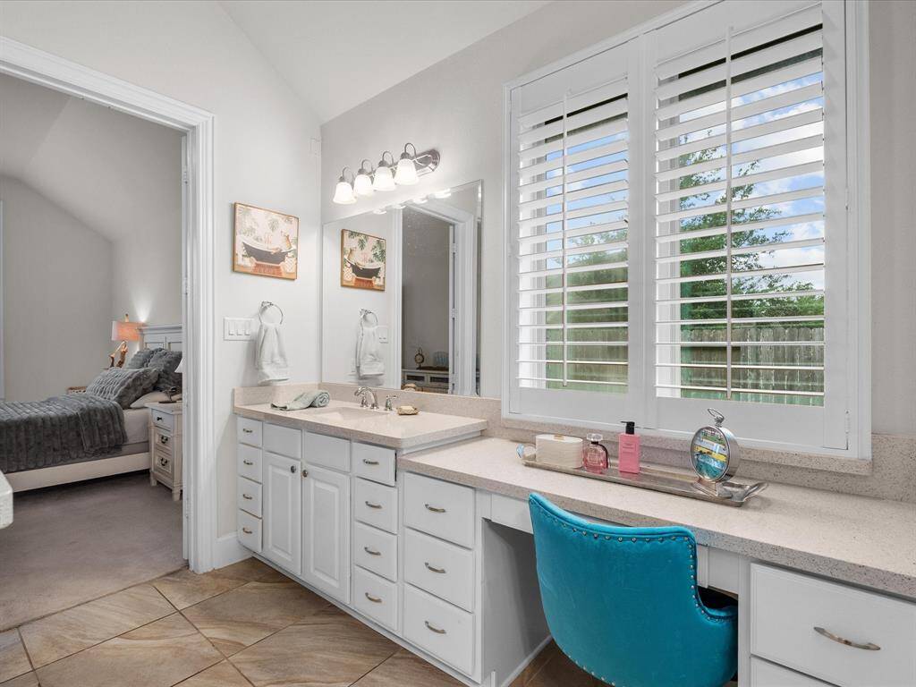 The dressing table is well lit from the large window and has many drawers for storage.