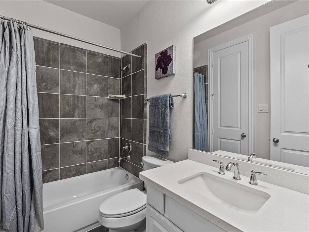 This bathroom features a modern design with a sleek white vanity, large mirror, and chrome fixtures.