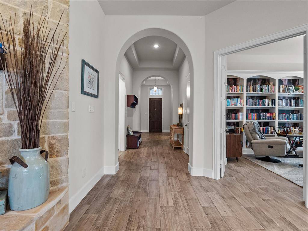 Beautiful arched looking back at the elegant entry gives a glimpse of the library/study from the family room.