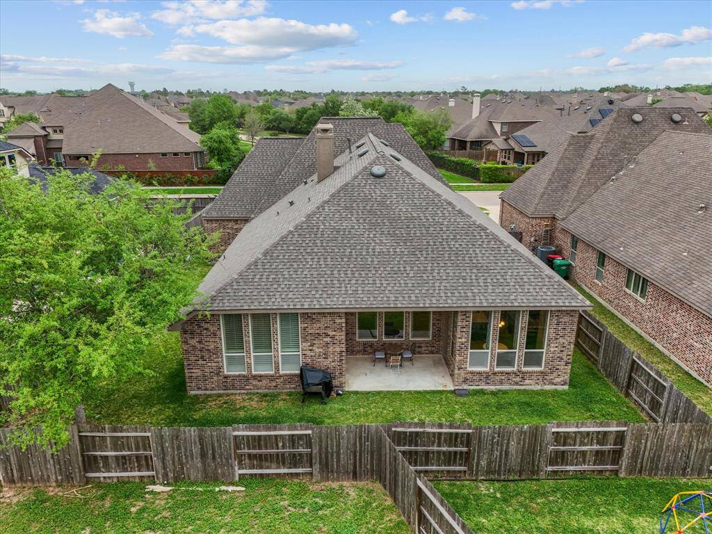 The backyard is flanked by privacy fencing and shaded by a mature tree. Large side yard shaded by trees!