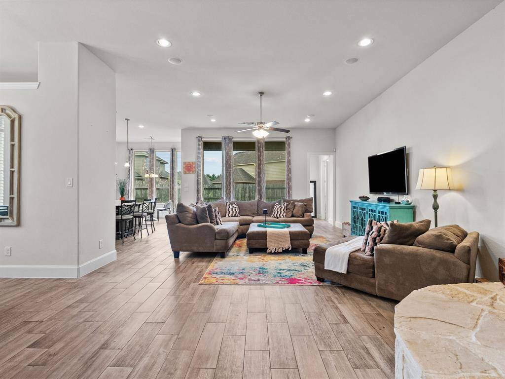 The family room is a large central hub of this house featuring high ceiling and lots of natural light from the over-sized windows.